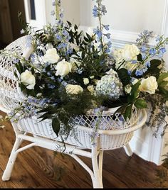 a wicker basket filled with white and blue flowers