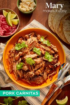 an orange bowl filled with pork carnitas next to sliced radishes and cilantro