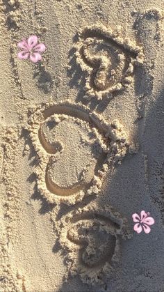 the word love is written in the sand with pink flowers on it and butterflies flying around