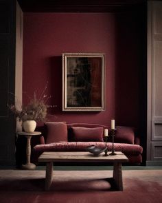 a living room filled with furniture and a painting on the wall above it's coffee table