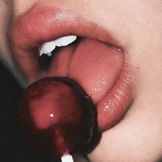 a close up of a person's lips with an apple in front of them