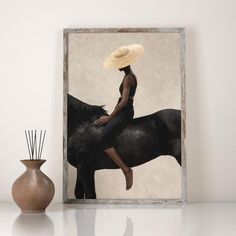 a woman sitting on top of a black horse next to a vase with reeds