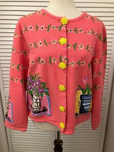 "Hand painted cotton cardigan sweater  Salmon pink w/ multicolored flowers and bright yellow daisy buttons Spring weight boho kitchy cardigan. Appears never worn. Ready to swing into spring in this fun cardigan Shoulder 17 1/2\" Chest 21\" pit to pit (42\" buttoned) Length 21 1/2\" bottom of neck to hem Sleeve 21 1/2\" ( 25 1/4\" from neck) Hem 42\" Buttons 6" Spring Cotton Cardigan With Floral Print, Spring Floral Print Cotton Cardigan, Vintage Floral Print Spring Cardigan, Pink Floral Print Sweater For Spring, Vintage Spring Sweater With Buttons, Vintage Pink Cardigan For Spring, Multicolor Button Sweater For Spring, Pink Cotton Cardigan With Buttons, Vintage Pink Cardigan With Buttons