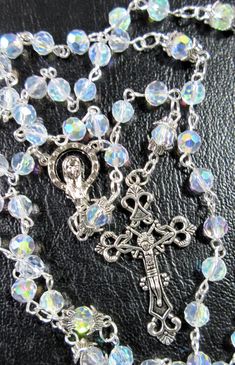 "This Catholic rosary is made of clear Aurora Borealis crystals. It is a complete 5 decades and a good gift for First Communion or a Baptism. The body is 26\" around and the cross drop is 5 inches. The rosary will be slipped into a velvet bag and shipped in a bubble mailer." Silver Beaded Rosary For First Communion, Silver Baptism Jewelry With 8mm Beads, Silver Faceted Beads Rosary Cross, Silver Jewelry With 8mm Beads For Baptism, Silver Spiritual Rosary Bracelet For First Communion, Silver Rosary Bracelet With Round Beads For Baptism, Silver Rosary For Baptism, Silver Rosary With Faceted Beads For Gift, Silver Rosary With Faceted Beads As Gift