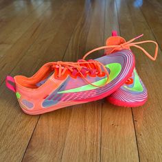 a pair of nike shoes sitting on top of a hard wood floor covered in neon colors