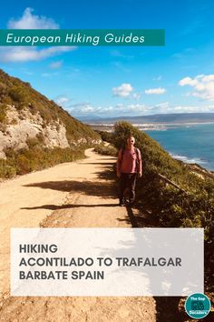 a person walking down a dirt road next to the ocean with text overlaying hiking acontladdo to trafalgar barbate spain