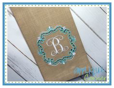 an embroidered monogrammed initial on a burlocked linen napkin with a blue border