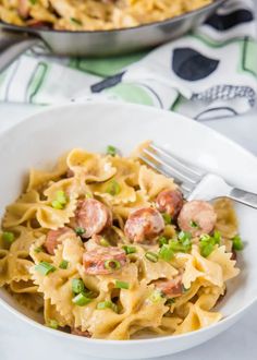 pasta with sausage and peas in a white bowl