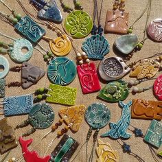 many different colored necklaces are laying on the table together with beads and pendants