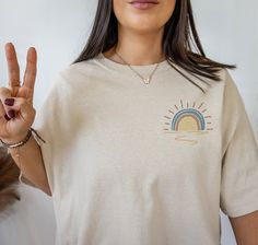 a woman is making the peace sign with her hand while wearing a t - shirt