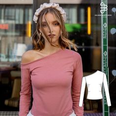 a woman standing in front of a store window wearing a pink shirt and white pants