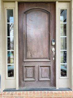 a front door with two sidelights and a brick step leading up to the entrance