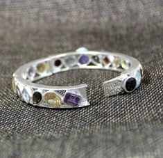 Wedding Jewelry Eternity Bangle Bracelet Clutch Lock Vibrant Gemstone 925 Sterling Silver Jewelry Engagement Gift Valentine Gift ,This Clutch lock Bangle cuff is made of solid 925 Sterling Silver studded with Genuine semi precious gemstones : Garnet, Amethyst, Citrine, Peridot , Smoky Quartz .They give a joyous brilliant aura to the jewelry piece .This simple but eye catcher bangle with is prominent multi color gemstones . SKU - ETB1003 Style - multi stone bangle Gemstone - multi stone Metal - 9 Wedding Bangle Jewelry With Gemstone Accents, Wedding Bangle Bracelet With Gemstone Accents, Sterling Silver Gemstone Bangle For Wedding, Anniversary Bracelet With Gemstone Accents, Anniversary Multi-stone Bangle Bracelet, Multi-stone Bracelets For Wedding, Fine Jewelry, Fine Jewelry Multi-stone Bracelets For Wedding, Multi-stone Fine Jewelry Bracelets For Wedding, Sterling Silver Gemstone Bangle For Anniversary