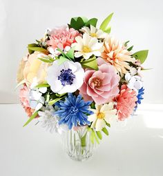 a vase filled with lots of different colored flowers