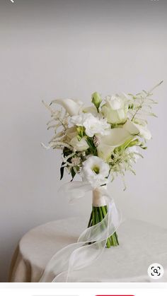 a bouquet of white flowers sitting on top of a table