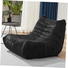 a black bean bag chair sitting on top of a rug