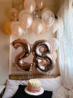 a birthday cake and balloons in the shape of the number twenty