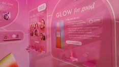 a pink display with pictures and text on the wall that says glow for good in front of it