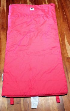 a pink sleeping bag is on the floor