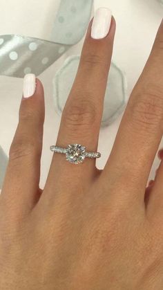 a woman's hand with a ring on it and a diamond in the middle