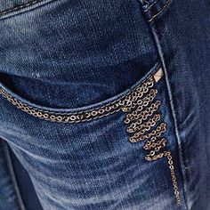 the back pocket of a pair of jeans with chains on it