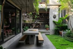 an outdoor dining area with table, bench and potted plants in the back yard