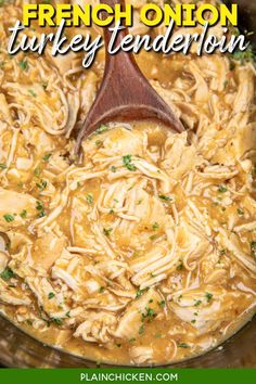 chicken noodle soup in a crock pot with a wooden spoon on the side