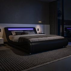 a large bed sitting in a bedroom next to a night stand with lights on it