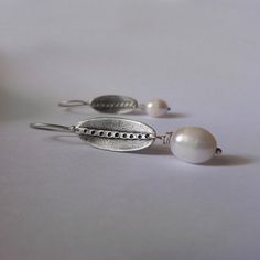 Minimal and elegant white freshwater pearl earrings. These handmade earrings are made from 925 sterling silver, with modern, minimal contemporary design and satin finish are great for everyday wear, but for special occasions also! Great gift for bridesmaids, mother's day or for an anniversary. ► DESCRIPTIONS and MEASUREMENTS: Handmade from 925 sterling silver The black area is oxidized to create contrast in the design. The line sanded to a satin, matte contrast. Pearl size: 18 x 10 mm Oval measu Sterling Silver Pearl Charm Earrings For Anniversary, White Sterling Silver Pearl Earrings For Anniversary, Pearl White Sterling Silver Pearl Earrings For Gift, Pearl White Sterling Silver Earrings For Gift, Sterling Silver Pearl White Earrings For Anniversary, Handmade Minimalist White Pearl Earrings, Handmade White Minimalist Pearl Earrings, Minimalist Handmade White Pearl Earrings, Anniversary White Pearl Earrings In Sterling Silver