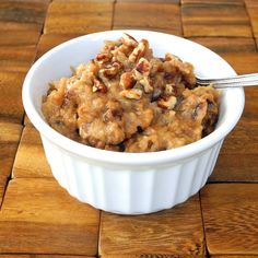 a bowl filled with oatmeal and nuts on top of a wooden table