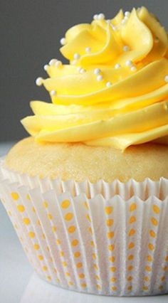 a cupcake with yellow frosting and white icing