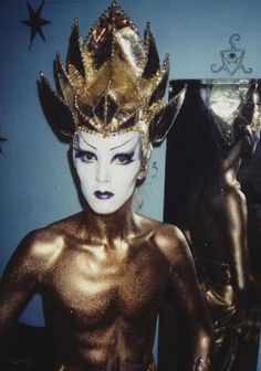 an image of a woman with gold paint on her face and body wearing a crown