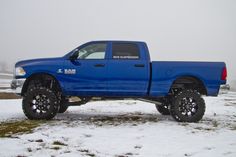 a blue truck is parked in the snow