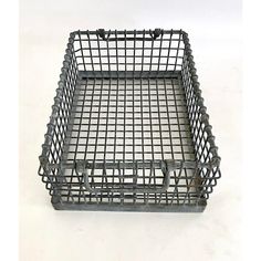 an empty metal basket on a white surface