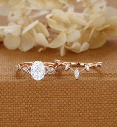 a close up of a diamond ring on a cloth with flowers in the back ground