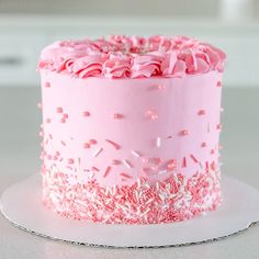 a pink frosted cake with sprinkles on it