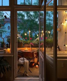 an open door leading into a kitchen with candles on the table and potted plants