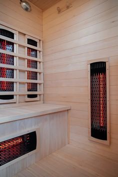 an empty room with two heaters on the wall and wooden shelves in front of it