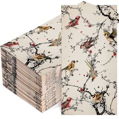 a stack of papers with birds and berries printed on the front, sitting next to each other