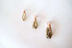 three different types of earrings on a white surface