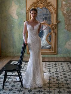 a woman in a wedding dress standing next to a chair