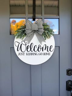 a welcome sign hanging on the front door of a house that says,'welcome just kidding go home '