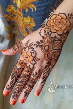 a woman's hand with henna tattoos and flowers on the palm, which is decorated