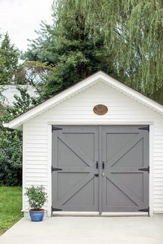 the garage is painted gray and has two doors in it, with an attached planter