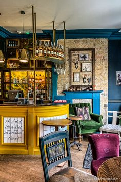 the interior of a bar with colorful chairs