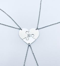 a heart shaped puzzle piece is attached to a chain with two smaller pieces on it