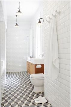 a white bathroom with black and white checkered flooring on the walls is featured in an instagram