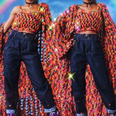 two women standing next to each other in front of a rainbow colored background