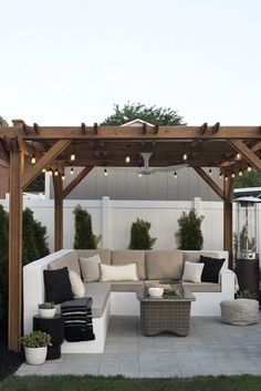 an outdoor living area with couches, tables and lights on the ceiling is shown