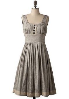 a dress on a mannequin with buttons in the front and bottom, sitting on a